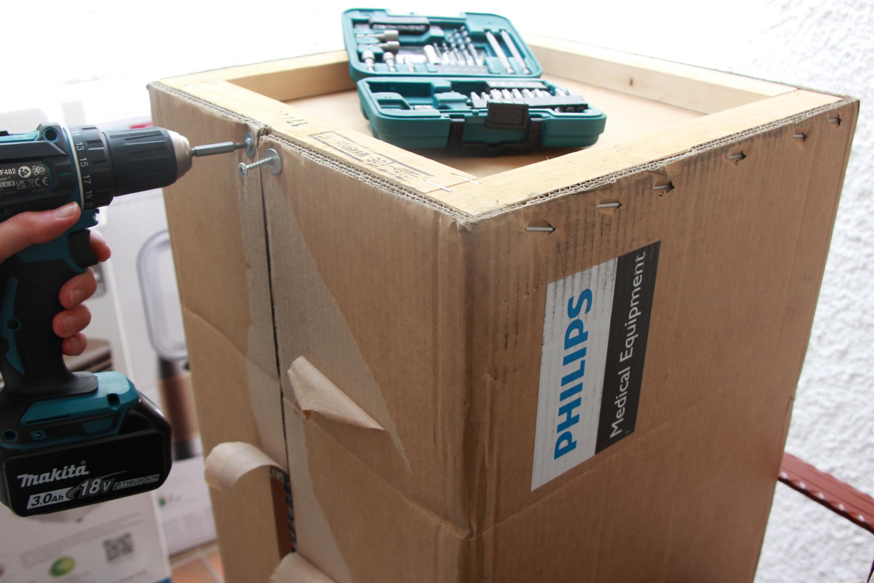 Der Karton des Philips Air Performer 8000 (AMF870/15) ist mit Torx-Schrauben sicher verpackt und es wird darauf gezeigt.